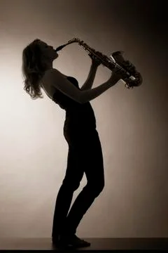 Woman playing saxophone, sepia toned. Stock Photos