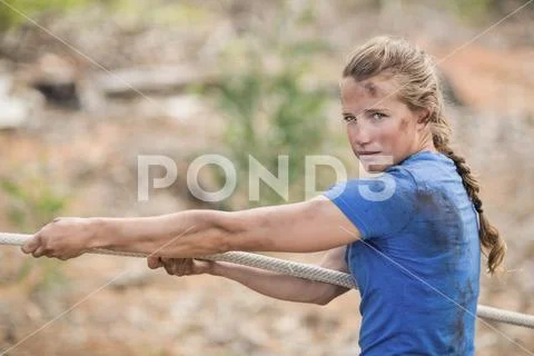 Photograph: Woman playing tug of war during obstacle course #74242152