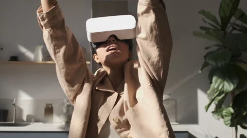 Woman playing using VR goggles at home. Girl wearing virtual reality headset. Stock Footage 250403347