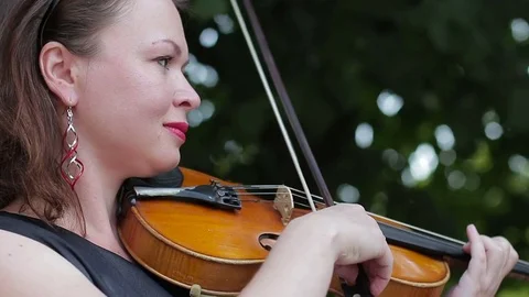 Woman playing the violin in the garden Stock Footage