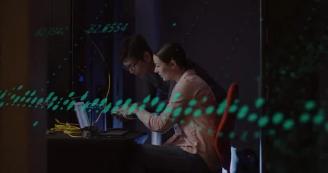 Woman plugging LAN cable into laptop, coding with man observing, projecting Stock Footage 310385570