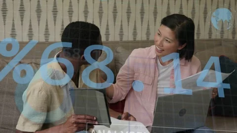 Woman pointing to laptop while man leaning in checking financial figures with Stock Footage 333803468