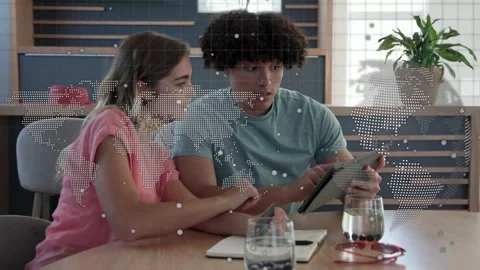 Woman pointing, man tapping tablet in tech meeting, overlay map updating as pair Stock Footage 333602689
