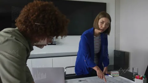 Woman pointing at plan, man leaning in, initiating animated data graphs for Stock Footage 333552440