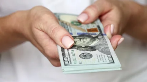 Woman pointing the stack of US Dollars towards the camera, closeup on hands Stock Footage 266927593