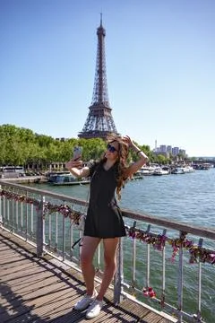 Woman posing on bridge with Eiffel Tower view in Paris Stockfoto's