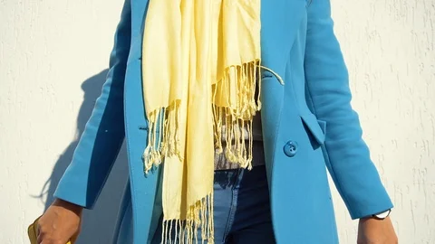 Woman posing in a coat on the background of the wall with the handbag Stock Footage 104866162