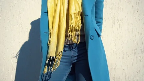Woman posing in a coat on the background of the wall with the handbag Stock Footage 104866164