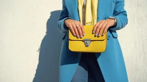 Woman posing in a coat on the background of the wall with the handbag Video stock 104866236