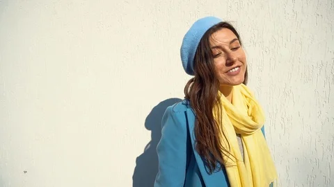 Woman posing in a coat on the background of the wall with the handbag Stock Footage 104866237