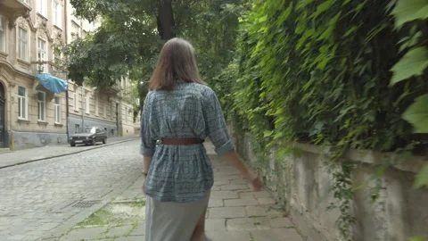 Woman posing in front of camera, walking by overgrown fence touching leafe Stock-Footage 145991645