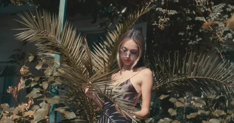 A woman is posing in front of a palm tree Stock-Footage 283824209