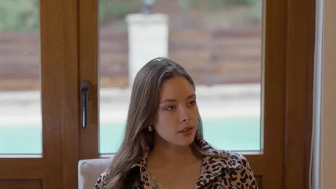 Woman is Posing Gracefully in a Beautiful Leopard Print Outfit by the Window Stock Footage 304498656