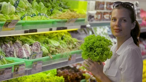 Woman posing. looking at camera smiling holding lettuce in organic vegetables Stock Footage 123091012