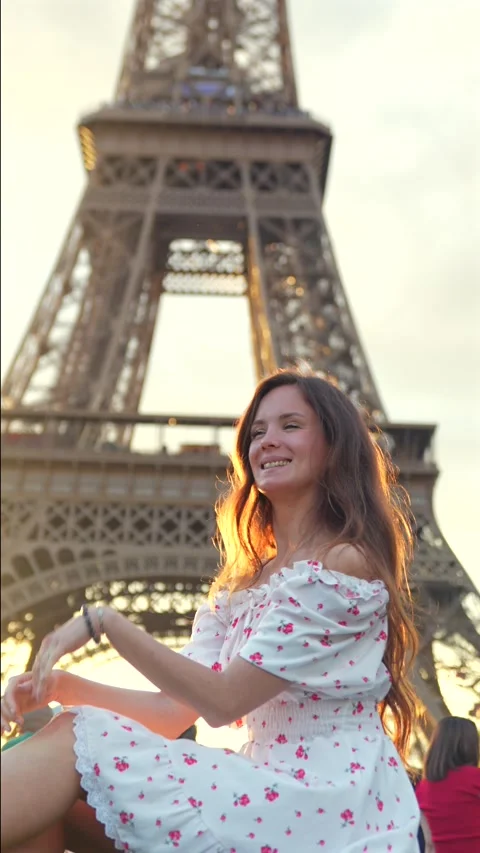Woman posing near Eiffel Tower in evening sunlight in Paris Stock Footage 313797097