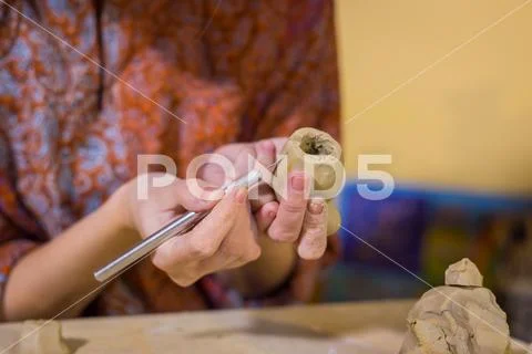 Woman potter making ceramic souvenir penny whistle in pottery workshop Stock Photos