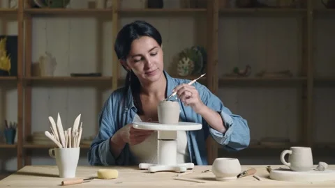 Woman potter using tools to making ceramic clay cup in potter studio Video stock 143617546