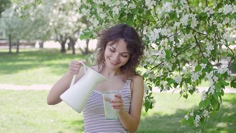Woman pouring juice from a jug on the background of Apple Stock Footage