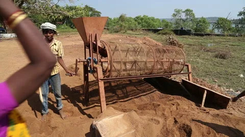Woman pouring soil in a processing machine, while boy works on it. Stock Footage 49803022