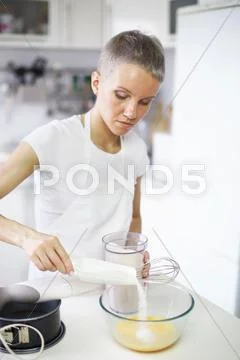Woman Pouring Sugar Into Mixing Bowl