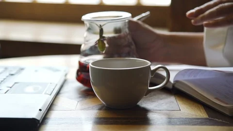 Woman Pouring Tea while Making notes in a Diary Stock-Footage 110997634