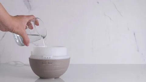 Woman pouring water in diffuser for essential oils Stock Footage 198928271