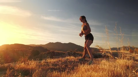 Woman powering through dynamic squats on a rocky hillside, radiating streng.. Stock Footage 341867572