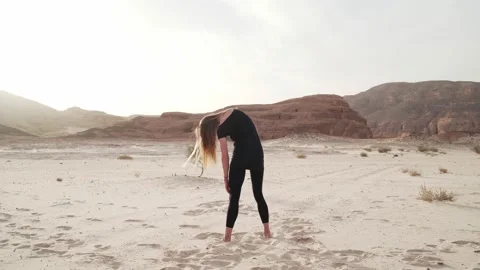Woman practice ecstatic dance in sandy desert in sunshine rapid slow motion Video stock 130795208