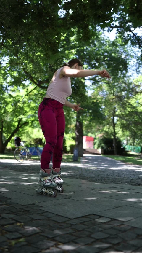Woman practices roller skating with an instructor watching her by video call Stock Footage 341476361