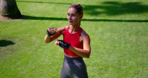 Woman Practicing Boxing Techniques in a Park Stock Footage 325751608