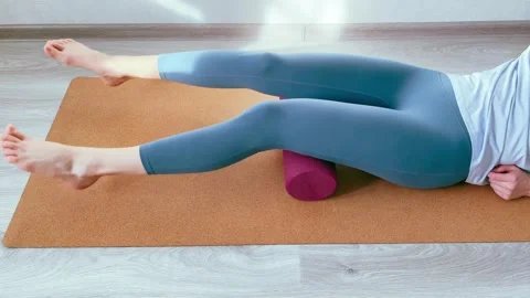 Woman practicing hamstrings myofascial release with foam roller Stock Footage 344302341
