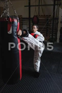Woman Practicing Karate With Punching Bag