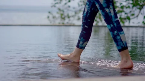 Woman practicing lord of the dance pose at infinity pool Stock Footage 75286014