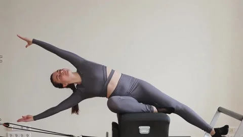 Woman practicing pilates on Reformer machine. Stock Footage 152405110