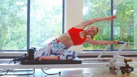 Woman practicing stretching exercise on reformer Stock Footage 112737795