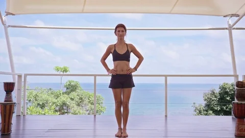 Woman practicing a tree pose against the sea 스톡 동영상 74770960