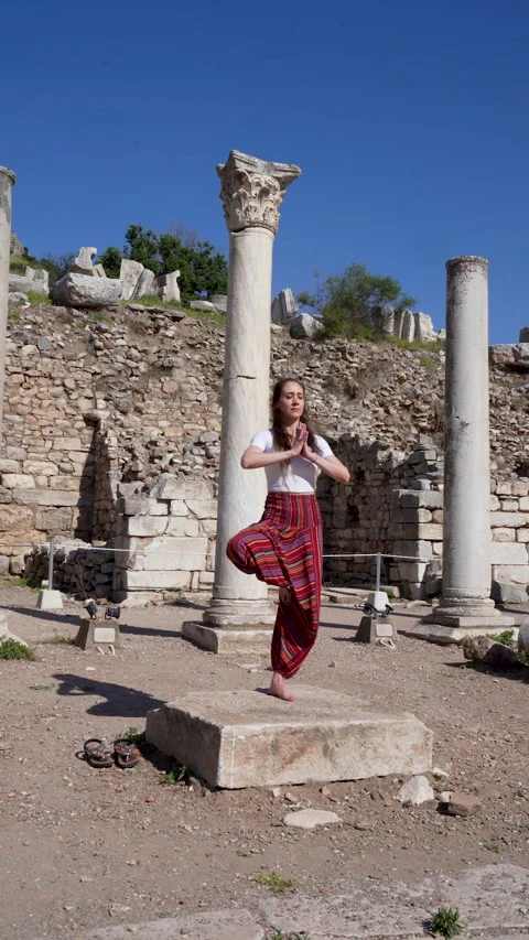 Woman practicing tree pose yoga at the ancient ruins of Ephesus Vídeos de archivo 336142681