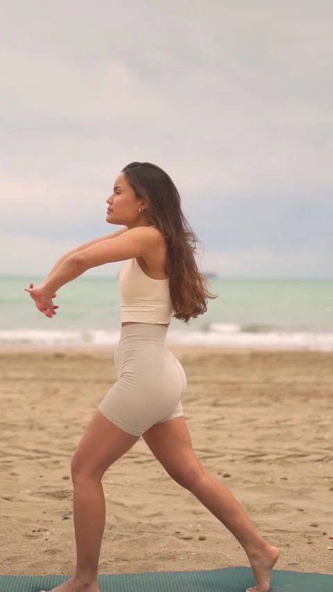 Woman Practicing Warrior Pose on Beach Stock Footage 275753095