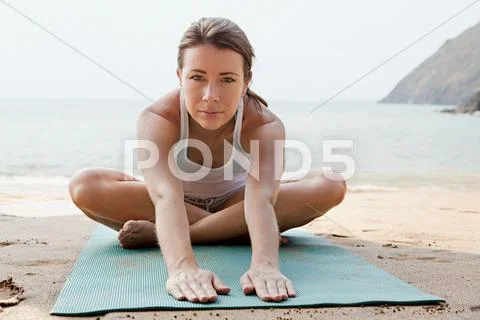 Woman Practicing Yoga On A Beach