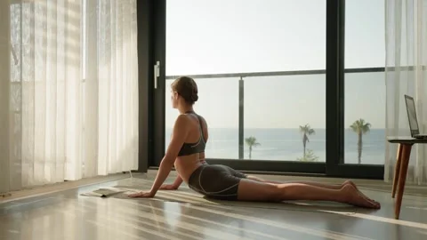 Woman Practicing Yoga During Remote Work Break with Ocean View. Видео 346104910