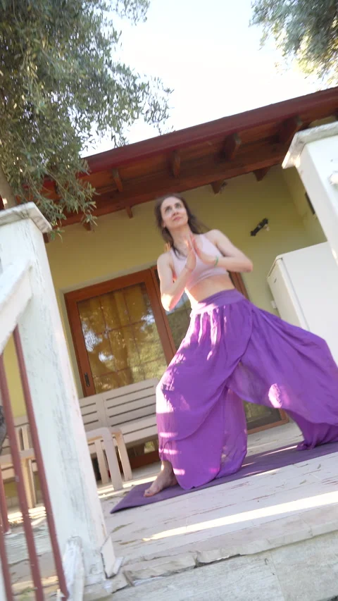 Woman practicing yoga flow on a rustic wooden porch in Sirince village Video stock 336130566