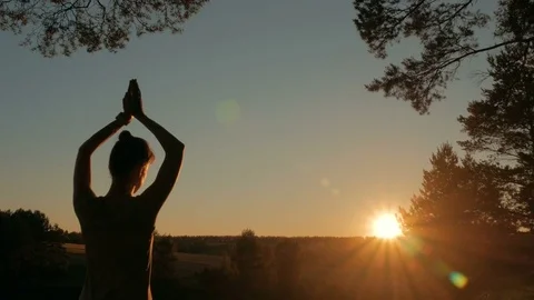 Woman practicing yoga in forest at sunset Stock Footage