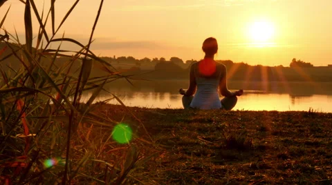 Woman Practising Yoga / meditating at sunset 4K Stock Footage 40602653