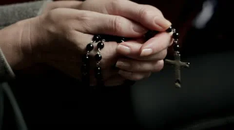 Woman praying with rosary beads Stock Footage