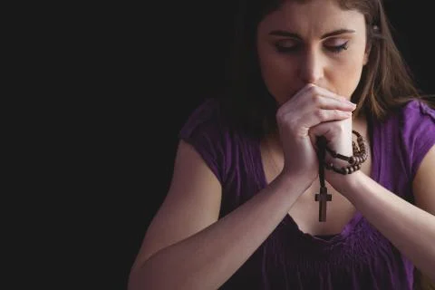 Woman praying with wooden rosary beads Stock Photos