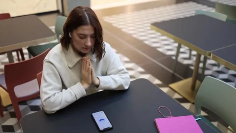 Woman prays using artificial intelligence on smartphone indoors Stock Footage 323738692