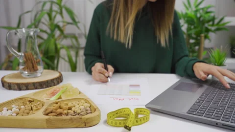 The woman prepares a diet program for herself at home. Healthy lifestyle. 库存影片 221154212