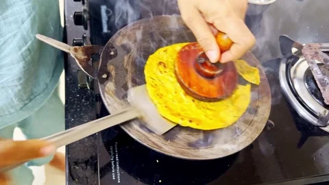 Woman prepares yellow flat bread on sizzling griddle 스톡 동영상 301438772