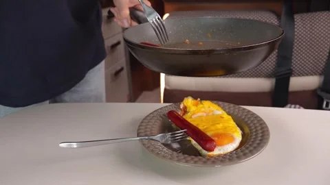 Woman preparing breakfast with fried egg and sausage Stock Footage 341565713