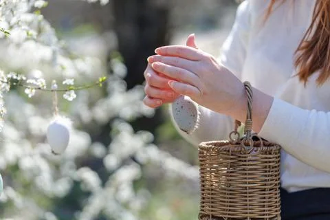 Woman preparing Easter decoration with egg and basket Стоковые фото